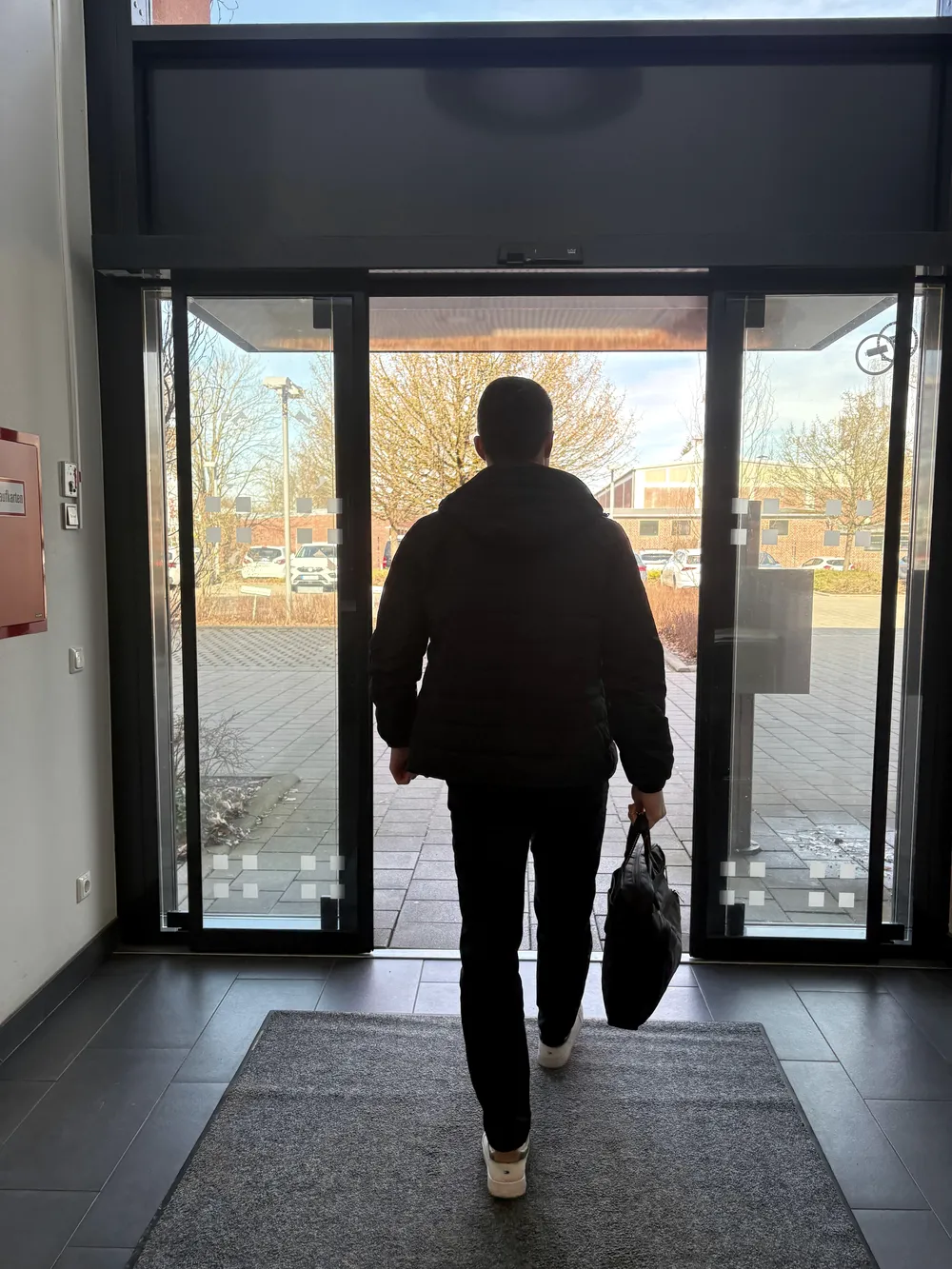 Carl Wiesemann verlässt mit Tasche ein Bürogebäude auf dem Weg zum nächsten Termin